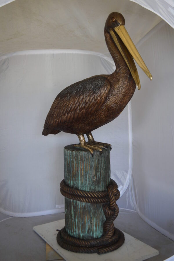 Pelican on a Stump Bronze Statue -  Size: 14"L x 38"W x 58"H.