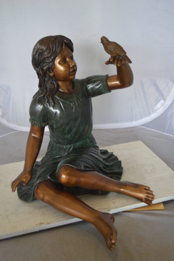 Girl with a Sparrow Bronze Statue -  Size: 24"L x 30"W x 25"H.