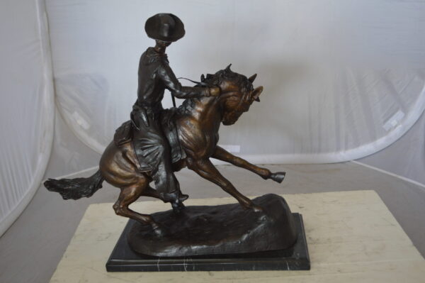 Remington Cowboy on marble Bronze Statue -  Size: 24"L x 9"W x 23"H.