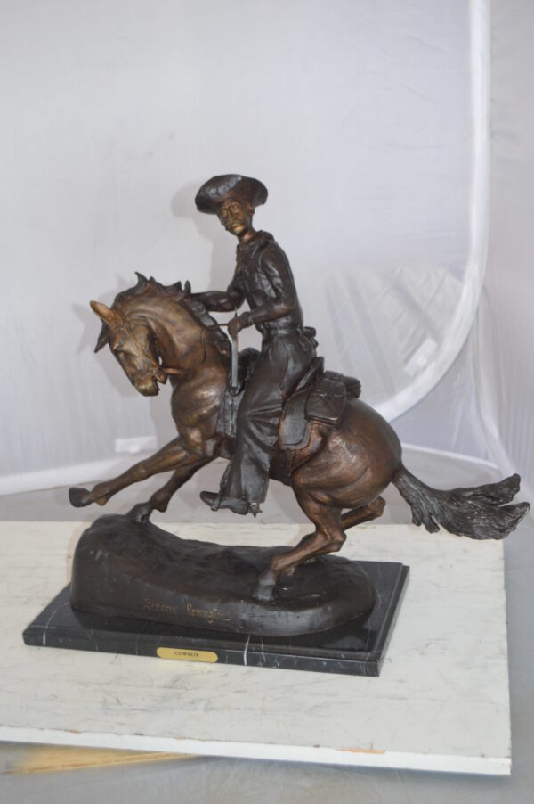 Remington Cowboy on marble Bronze Statue -  Size: 24"L x 9"W x 23"H.