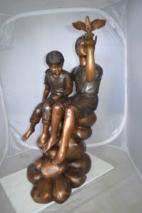 Two Kids on Rocks with a Bird Bronze Statue -  Size: 36"L x 30"W x 44"H.