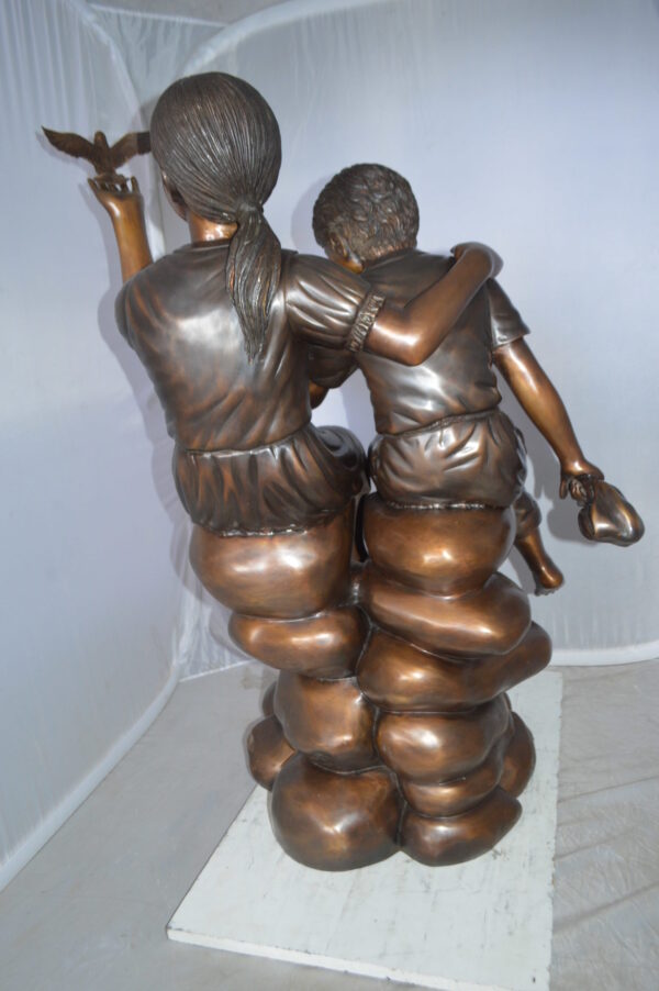 Two Kids on Rocks with a Bird Bronze Statue -  Size: 36"L x 30"W x 44"H.