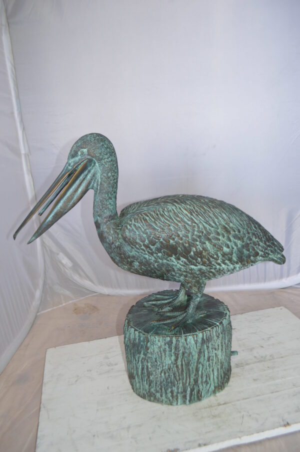 Pelican on a Tree Stump fountain bronze statue -  Size: 30"L x 16"W x 46"H.