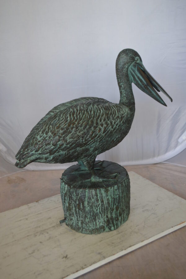 Pelican on a Tree Stump fountain bronze statue -  Size: 30"L x 16"W x 46"H.