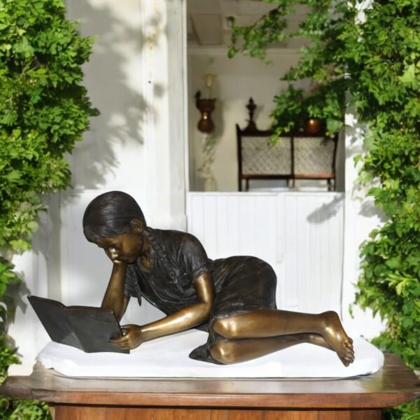 Girl laying reading a book Bronze Statue -  Size: 36"L x 17"W x 18"H. - Image 2
