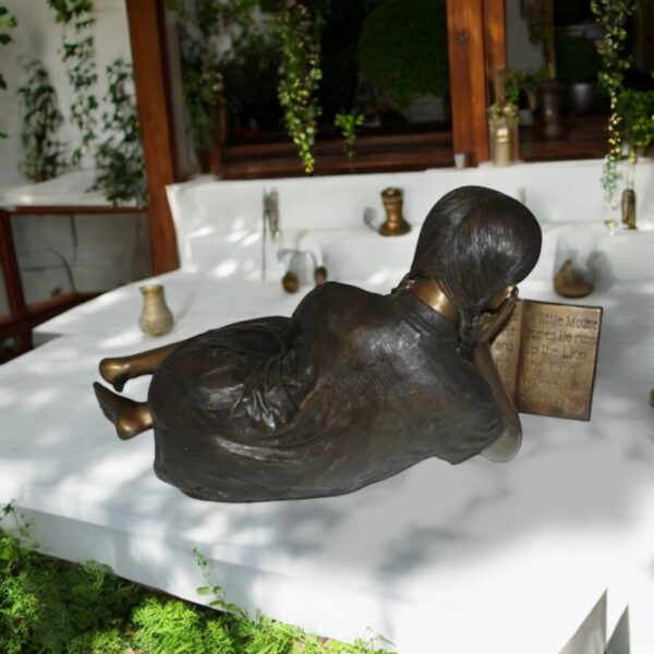 Girl laying reading a book Bronze Statue -  Size: 36"L x 17"W x 18"H. - Image 3