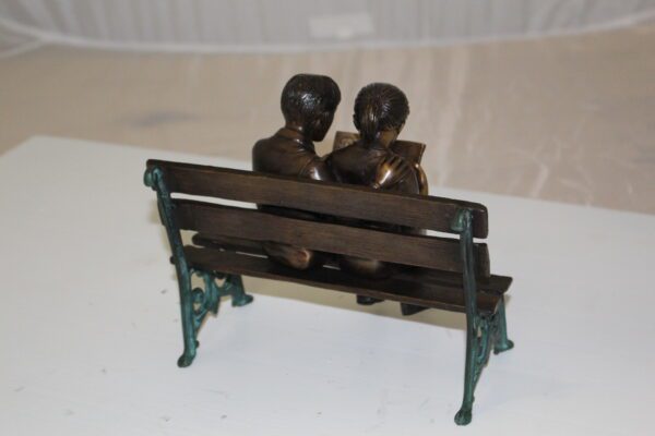 Two kids on bench reading a book - Bronze Statue -  Size: 9"L x 6"W x 8"H.