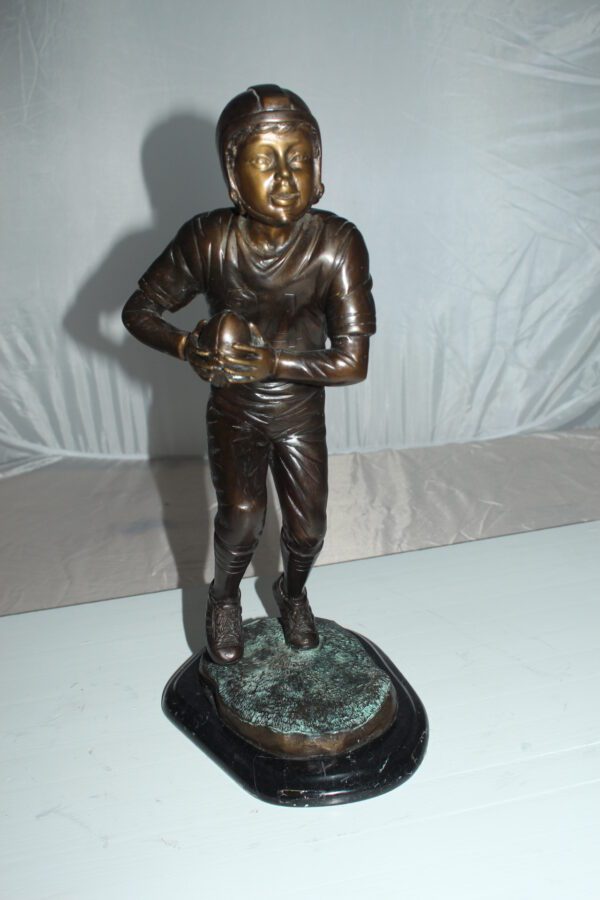 Boy playing football Bronze Statue -  Size: 10"L x 8"W x 20"H.