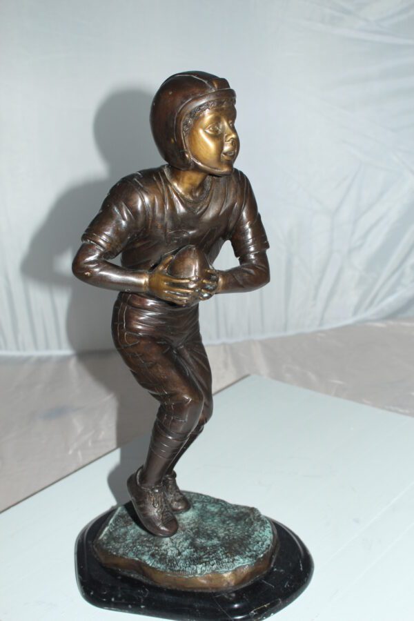 Boy playing football Bronze Statue -  Size: 10"L x 8"W x 20"H.