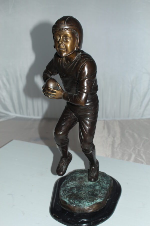 Boy playing football Bronze Statue -  Size: 10"L x 8"W x 20"H.