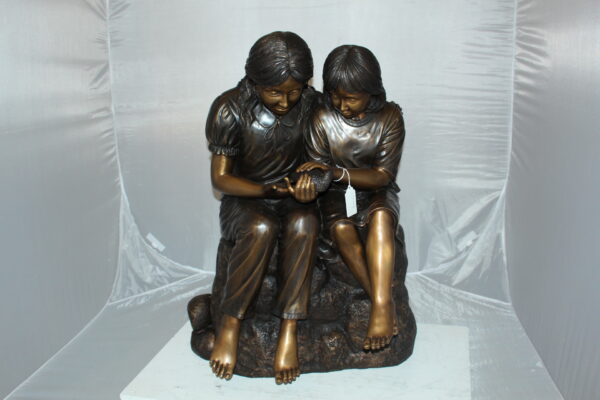 Two kids holding a bird Bronze Statue -  Size: 18"L x 26"W x 34"H.