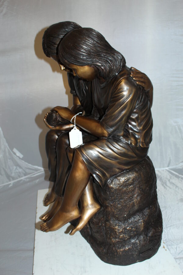 Two kids holding a bird Bronze Statue -  Size: 18"L x 26"W x 34"H.