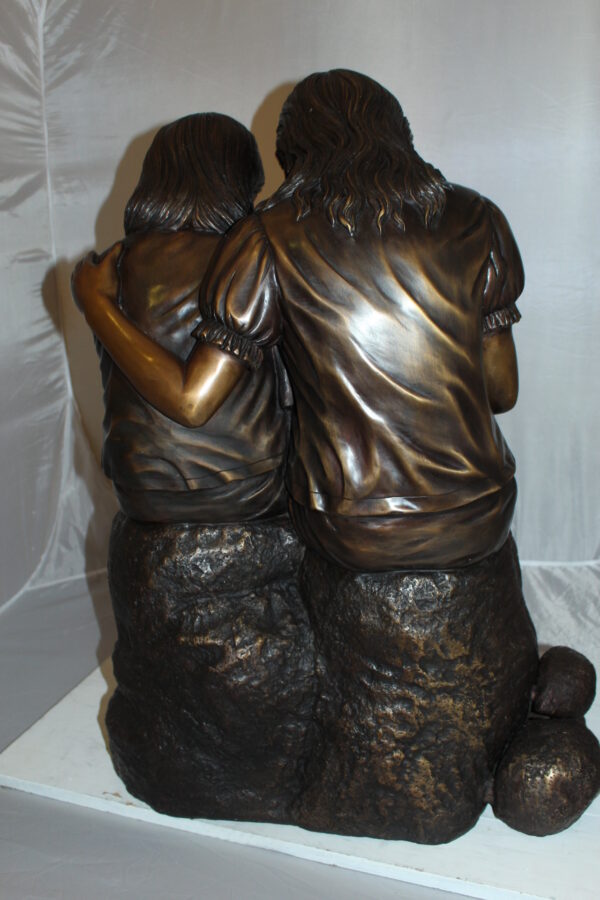 Two kids holding a bird Bronze Statue -  Size: 18"L x 26"W x 34"H.