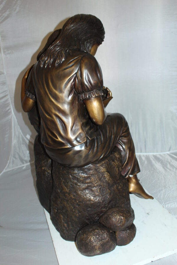 Two kids holding a bird Bronze Statue -  Size: 18"L x 26"W x 34"H.