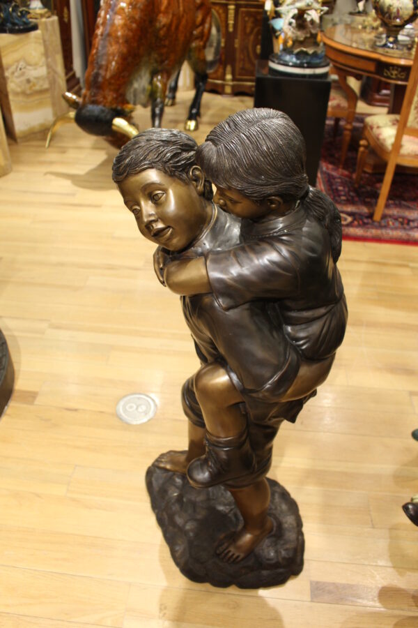 Boy Giving Girl Piggyback Ride Bronze Statue -  Size: 23"L x 16"W x 46"H.