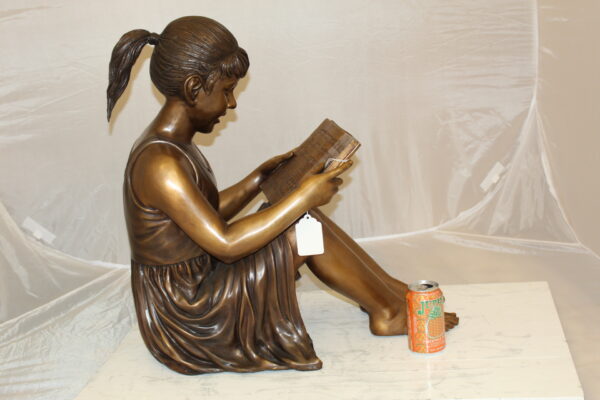 Girl Sitting and Reading a Book Bronze Statue -  Size: 23"L x 15"W x 24"H.