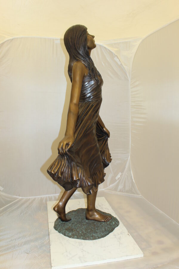 Lady holding her Skirt Bronze Statue -  Size: 32"L x 17"W x 53"H.