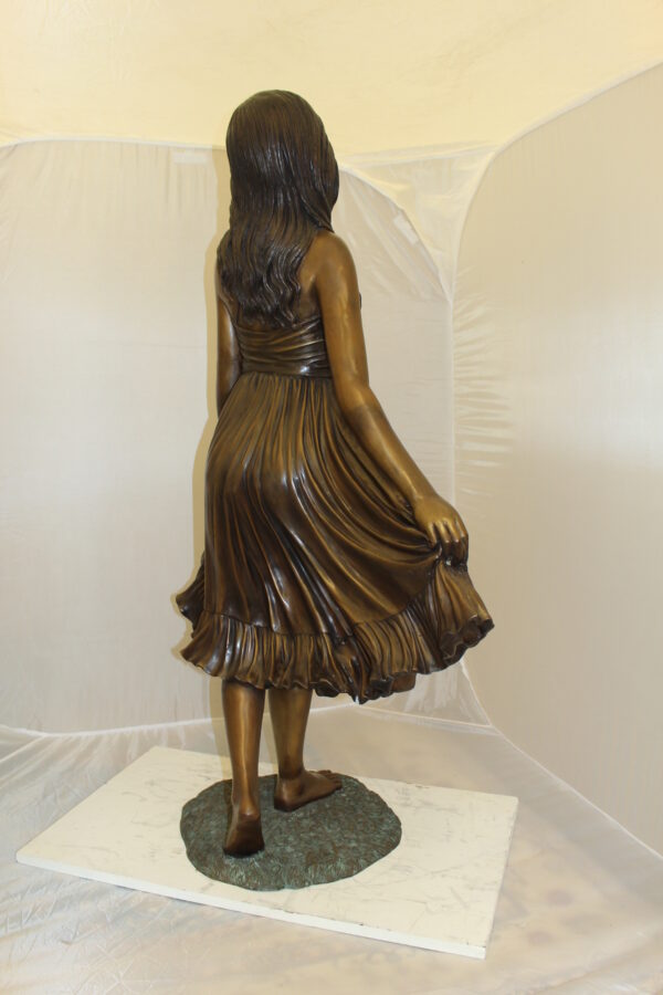 Lady holding her Skirt Bronze Statue -  Size: 32"L x 17"W x 53"H.