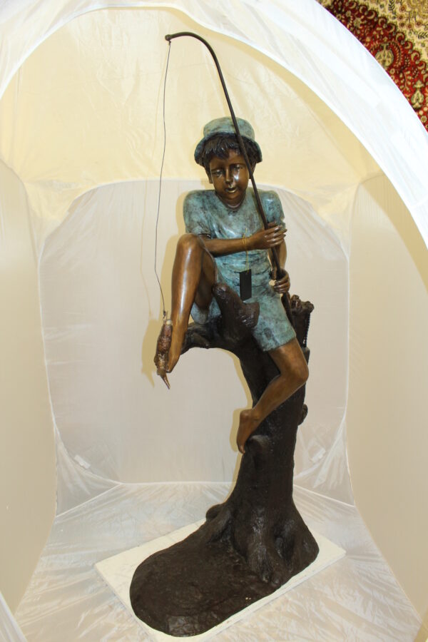 Boy Sitting on a Tree and Fishing Bronze Statue -  Size: 36"L x 21"W x 37"H.