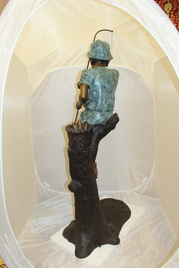 Boy Sitting on a Tree and Fishing Bronze Statue -  Size: 36"L x 21"W x 37"H.