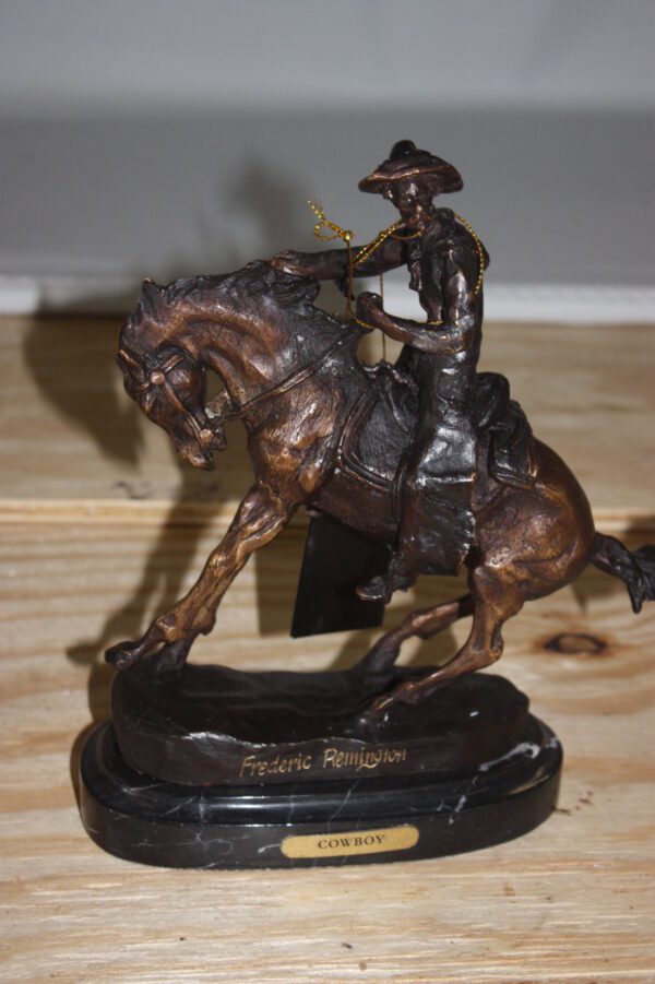 Remington Cowboy on marble Bronze Statue -  Size: 10"L x 3.5"W x 10"H.