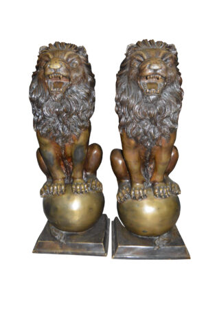 Pair of lions standing on balls, bronze statues -  Size: 14"L x 16"W x 38"H.