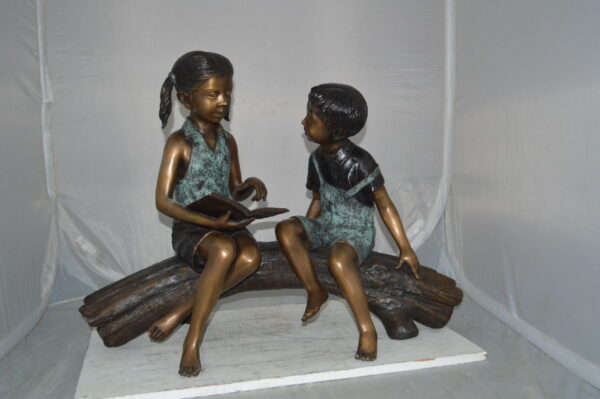 Boy and Girl on a tree log reading Bronze Statue -  Size: 37"L x 14"W x 27"H. - Image 3