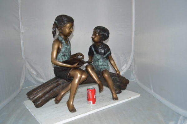 Boy and Girl on a tree log reading Bronze Statue -  Size: 37"L x 14"W x 27"H. - Image 4