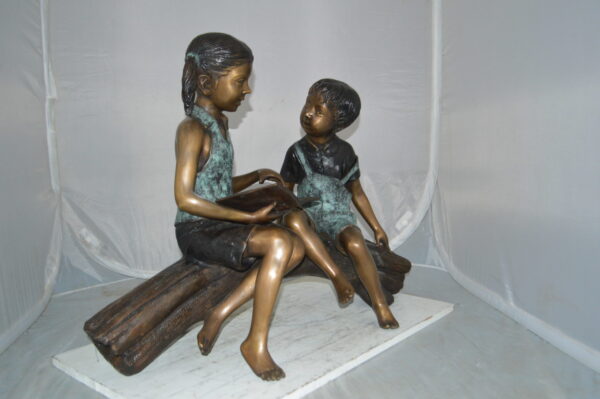 Boy and Girl on a tree log reading Bronze Statue -  Size: 37"L x 14"W x 27"H. - Image 6