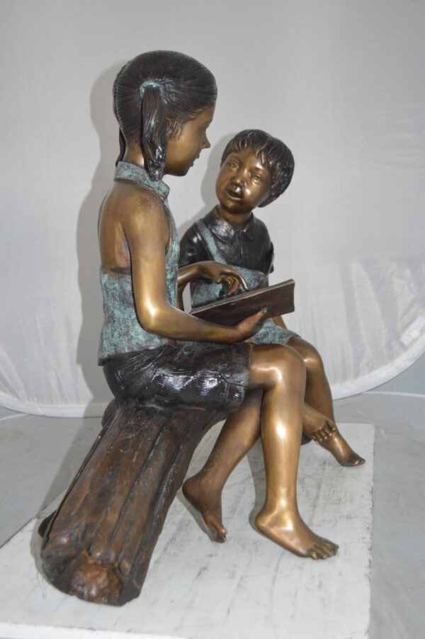 Boy and Girl on a tree log reading Bronze Statue -  Size: 37"L x 14"W x 27"H. - Image 7