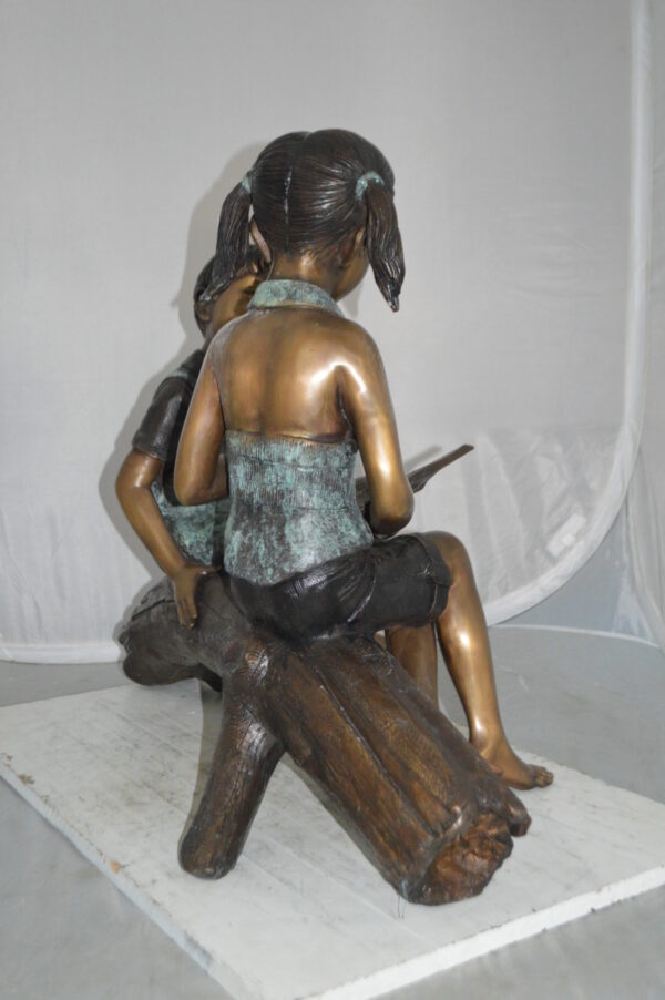 Boy and Girl on a tree log reading Bronze Statue -  Size: 37"L x 14"W x 27"H. - Image 8