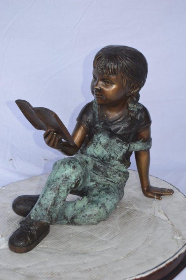 Young girl laying and reading book bronze statue -  Size: 18"L x 9"W x 16"H. - Image 2