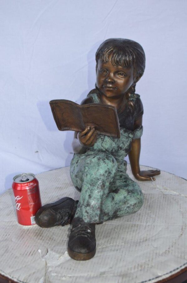 Young girl laying and reading book bronze statue -  Size: 18"L x 9"W x 16"H. - Image 3