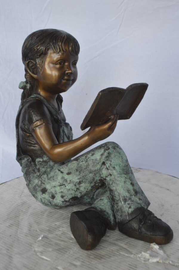 Young girl laying and reading book bronze statue -  Size: 18"L x 9"W x 16"H. - Image 4
