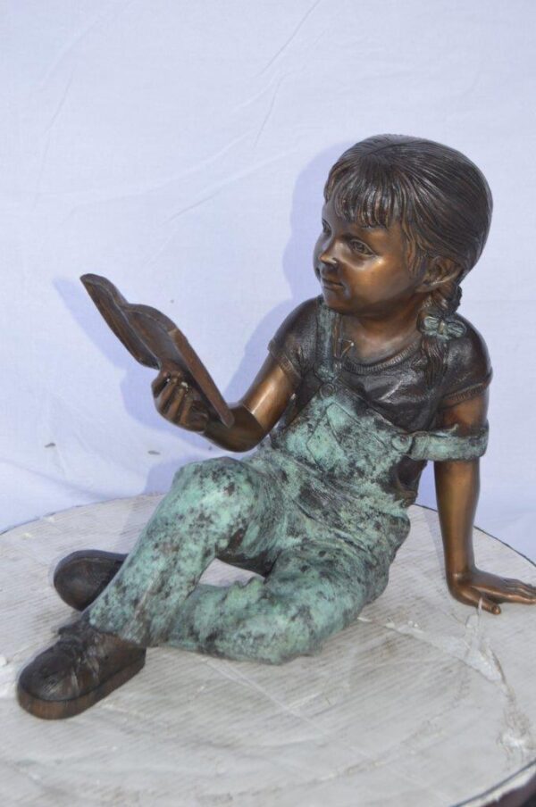 Young girl laying and reading book bronze statue -  Size: 18"L x 9"W x 16"H. - Image 9
