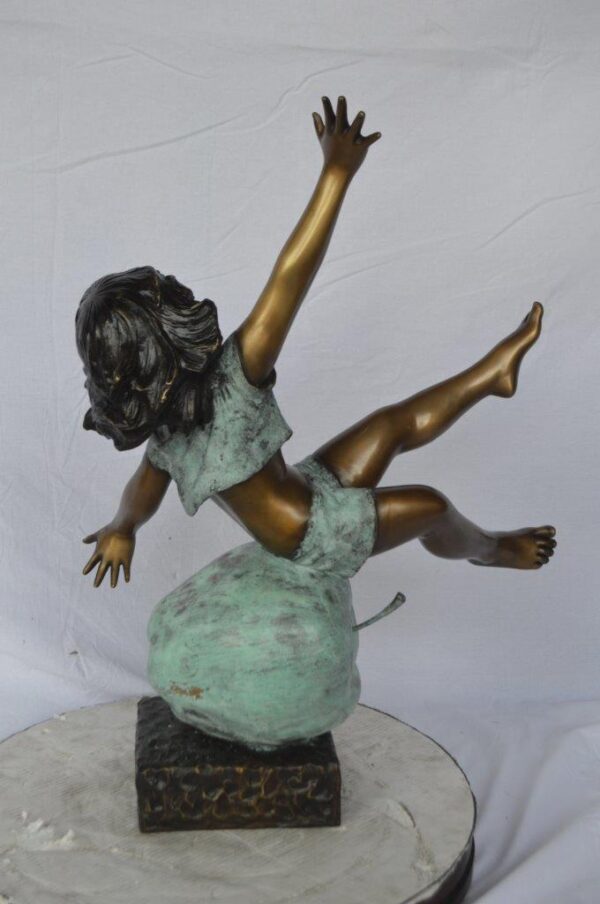 Girl having fun on apple bronze statue -  Size: 22"L x 9"W x 31"H. - Image 7