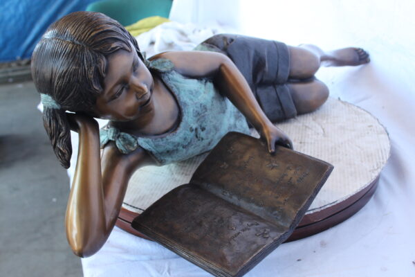 Peaceful young girl enjoying a read bronze statue -  Size: 40"L x 17"W x 13"H. - Image 9